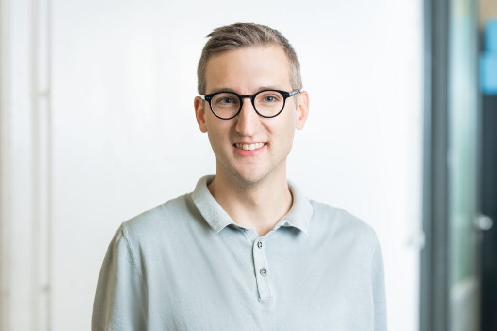 Junges Mann mit Brille vor einem weißen Hintergrund, Startup Labor Schwedt.